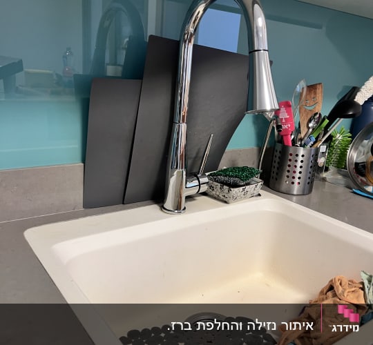 כיור מטבח עם ברז וכלים לניקוי